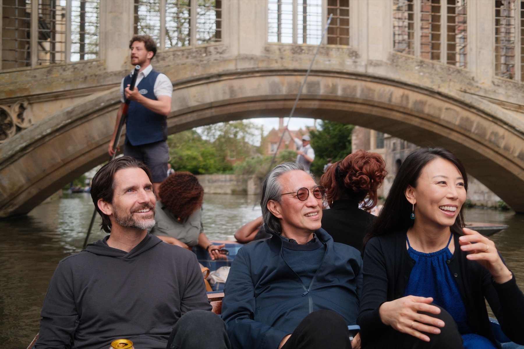 Members punting beneath a bridge